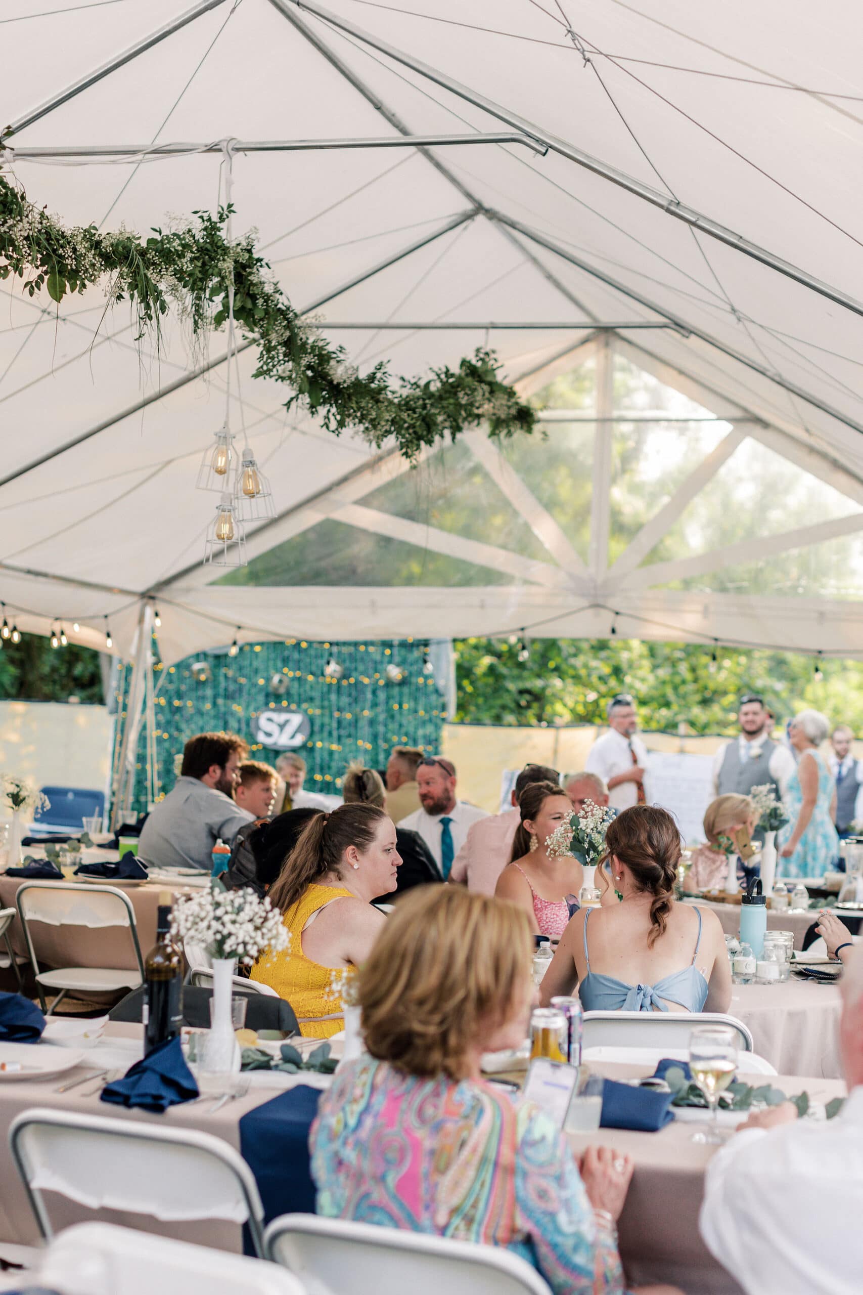 a backyard wedding tent with florals and greenery scaped designs
