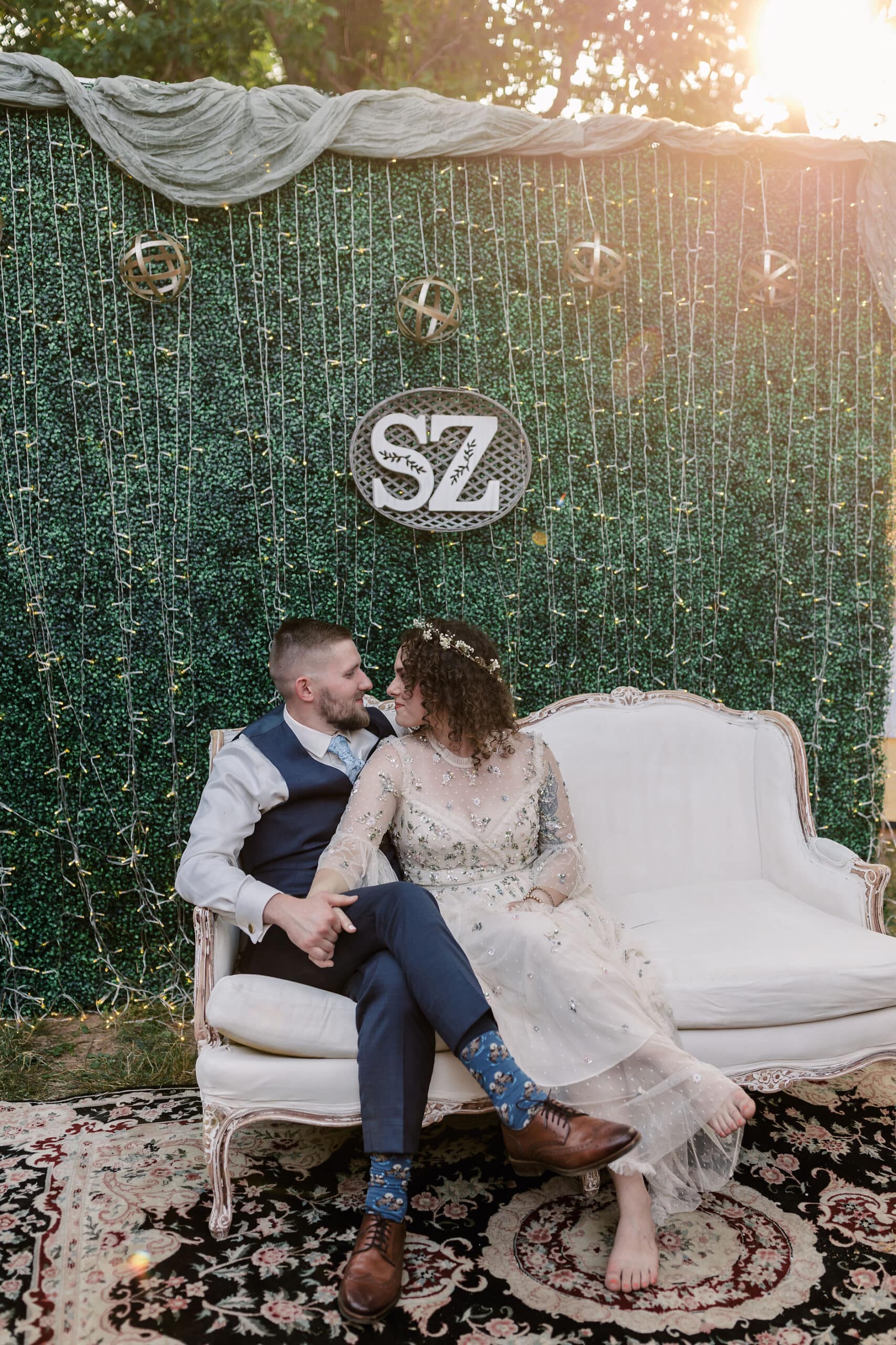 a bride and groom with their wedding backdrop for photos at reception