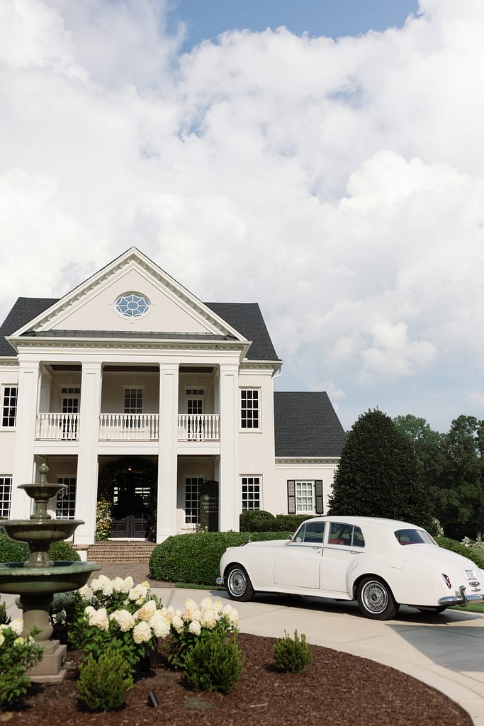 Donovan Manor North Carolina wedding venue exterior with vintage white car and hydrangea-lined drive