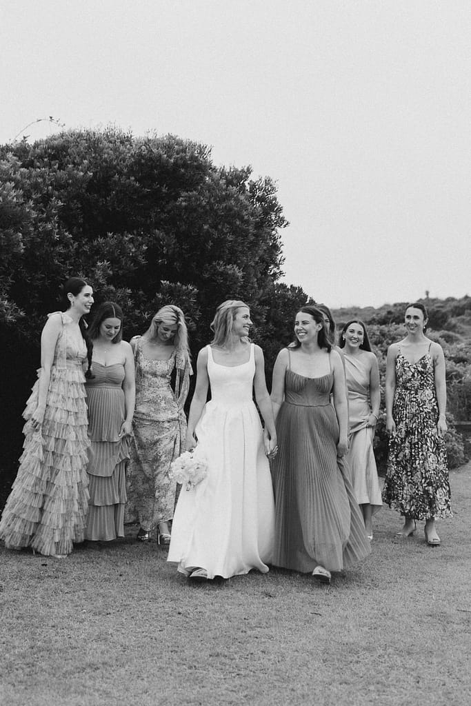 A bride walks with her bridesmaids at the Dunes Club 
