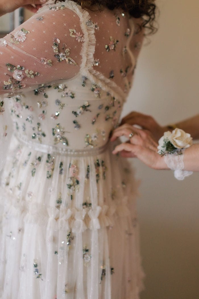 getting ready moments for a bride in woodbine maryland with a dress from the company needle and thread