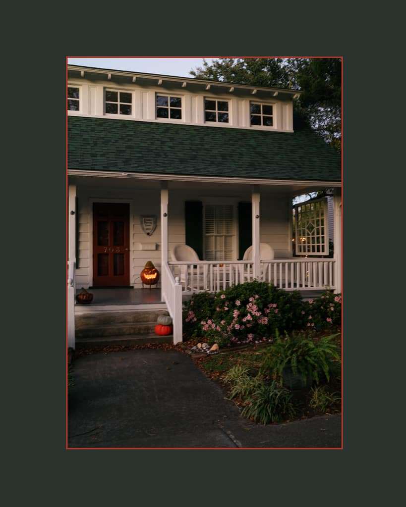 Cozy Beaufort NC home decorated for Halloween with a glowing jack-o-lantern on the porch, captured in golden evening light by Beaufort NC lifestyle photographer.