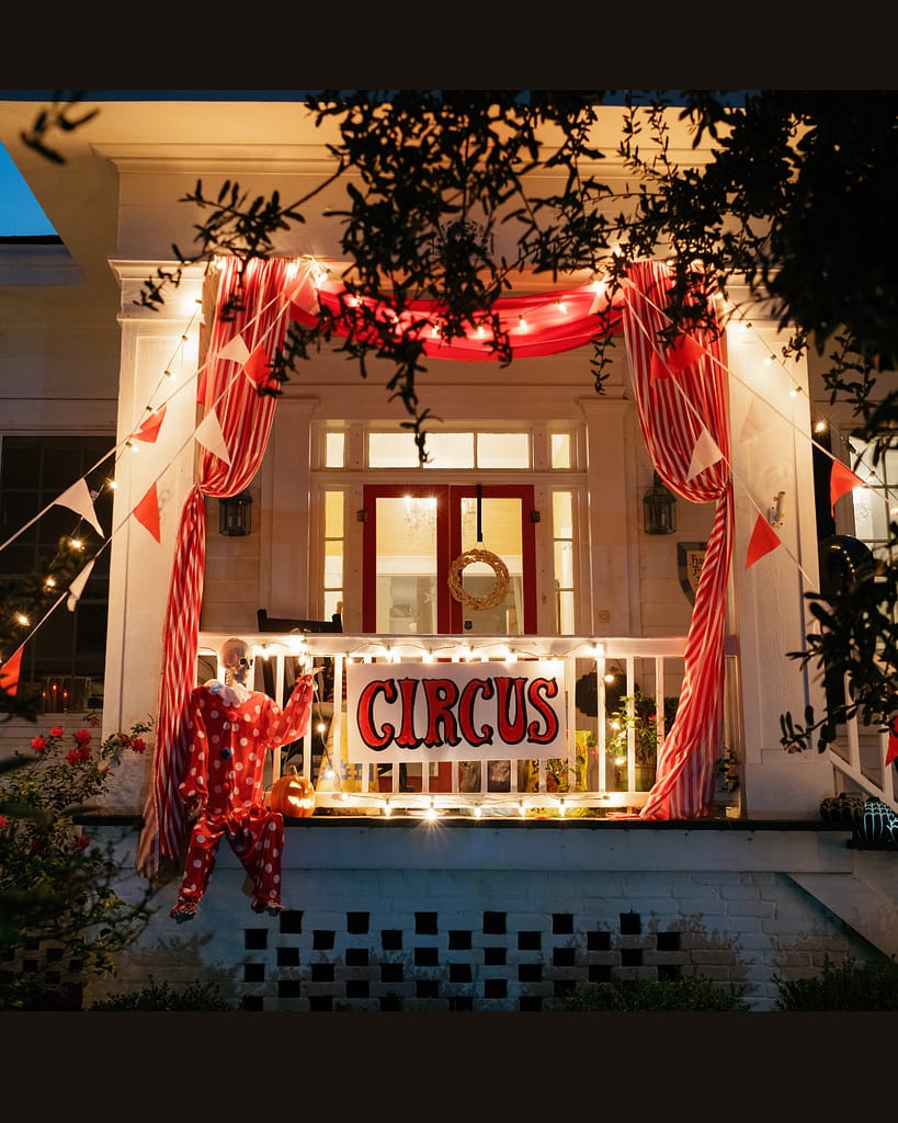 Festive circus-themed Beaufort NC porch with red and white drapes, glowing lights, and a hand-painted circus sign — photographed by Beaufort NC Hailey Rae photographer.