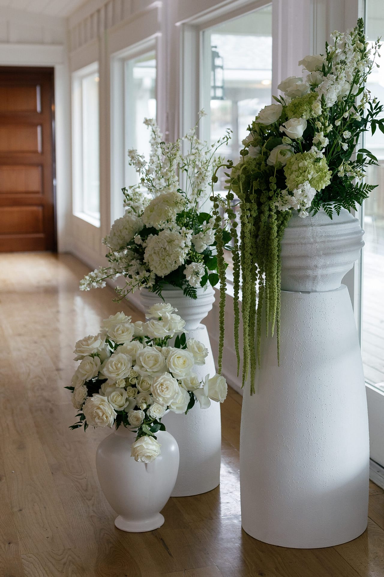 Large Vases filled with greenery and long stemmed florals surround the ceremony at the Dunes Club