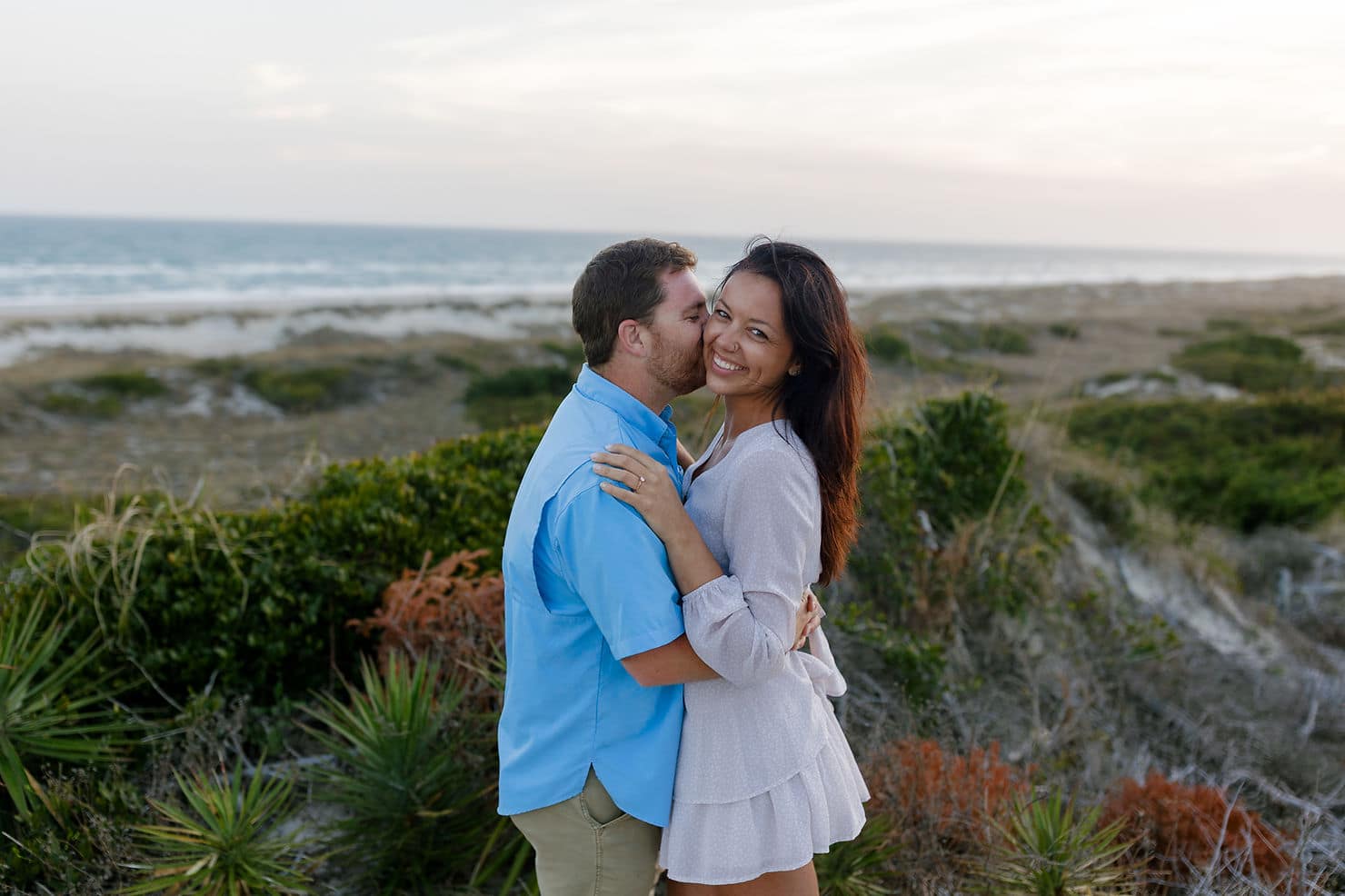 Couple embracing after proposal on Atlantic Beach

